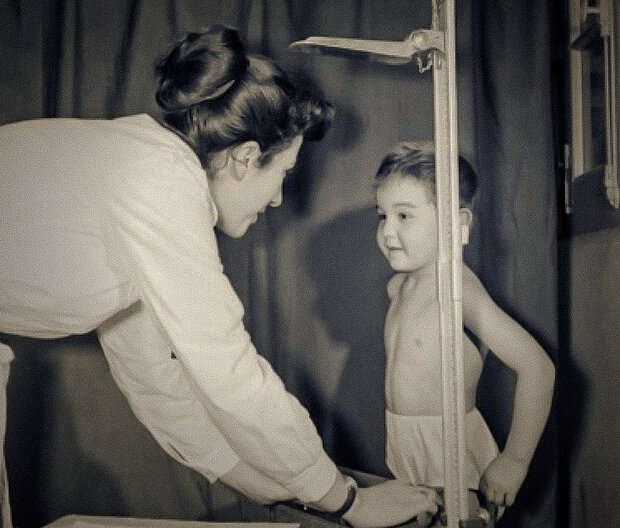 une doctoresse devant un enfant qu'elle mesure à la toise dans les années 1960, documentaire Voyage en santé